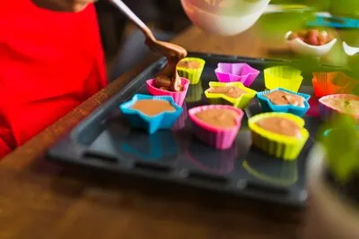 Crop person filling cups with butter