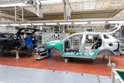 Car bodies are on assembly line Factory for production of cars Modern automotive industry A car being checked before being painted in a hightech enterprise
