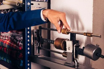 Close-up of a male fashion designer adjusting the fabric weighing scale machine