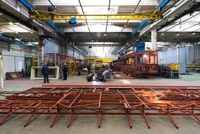 One working day of modern automatic bus trolleybus car production with unfinished cars workers in protective uniform in factory background automobile assembly line welding arm