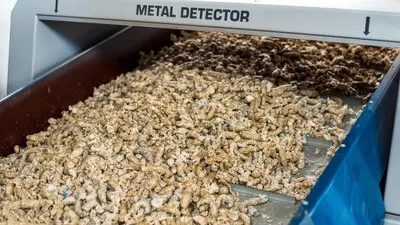 Pressed plastic garbage moving on a conveyor belt under metal detector at waste recycling factory
