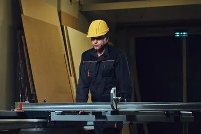 The woodworker is leaning at the wooden table.