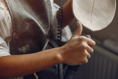 Young woman makes pottery in workshop