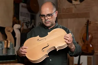 Man making instruments in his workshop alone