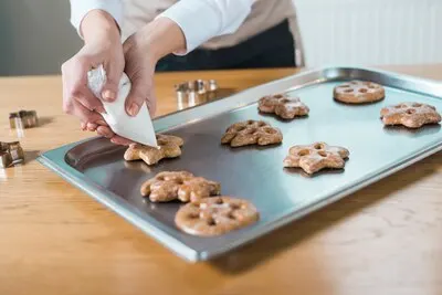 Pastry chef decorating delicious cookies of different shapes