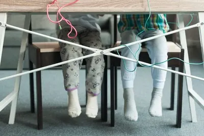 Legs of kids sitting at table