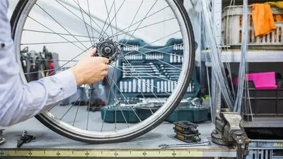 Man's hand repairing wheel of bicycle