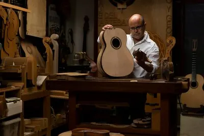 Middle aged man making instruments in his workshop alone