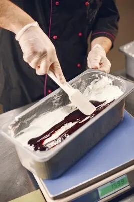 Making Of gelato chocolate ice cream.Confectioner in chef uniform is working on ice cream.