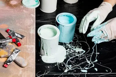 High angle of paint cans with spilled paint