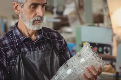 Glassblower examining glassware